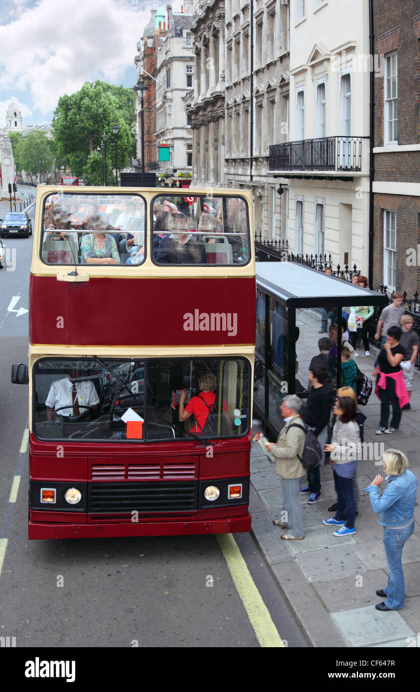 Red carrozze a due piani con i turisti su Street a Londra, Inghilterra. Le persone entrano in rosso double-decker. Foto Stock