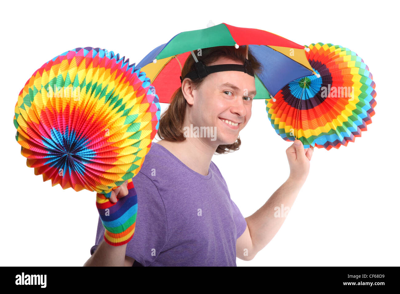 Ritratto di uomo felice con il rainbow hat ombrello sulla testa e colorfull ghirlanda di carta nelle mani Foto Stock