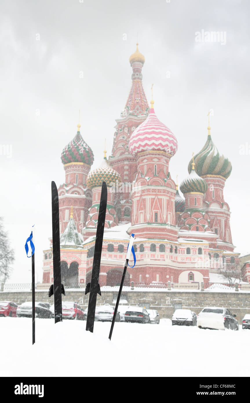 Sci da fondo e poli bloccato nella neve nella parte anteriore della Cattedrale di San Basilio a Mosca, Russia in inverno durante la nevicata Foto Stock