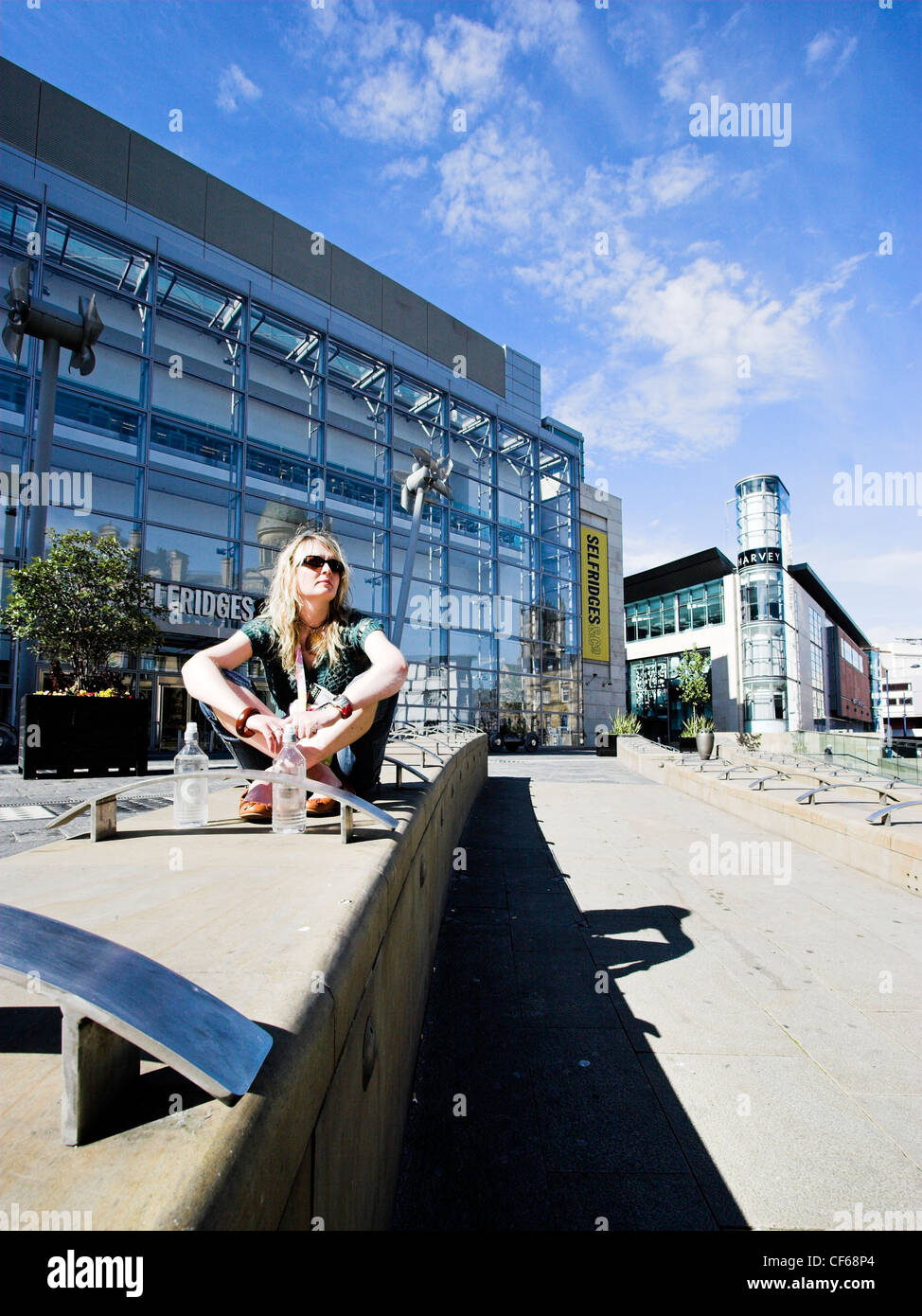 Una donna per godersi il sole in Exchange Square in Manchester. Questa area è stata ricostruita nel 1996 dopo una massiccia bomba dell'IRA decimato la Foto Stock