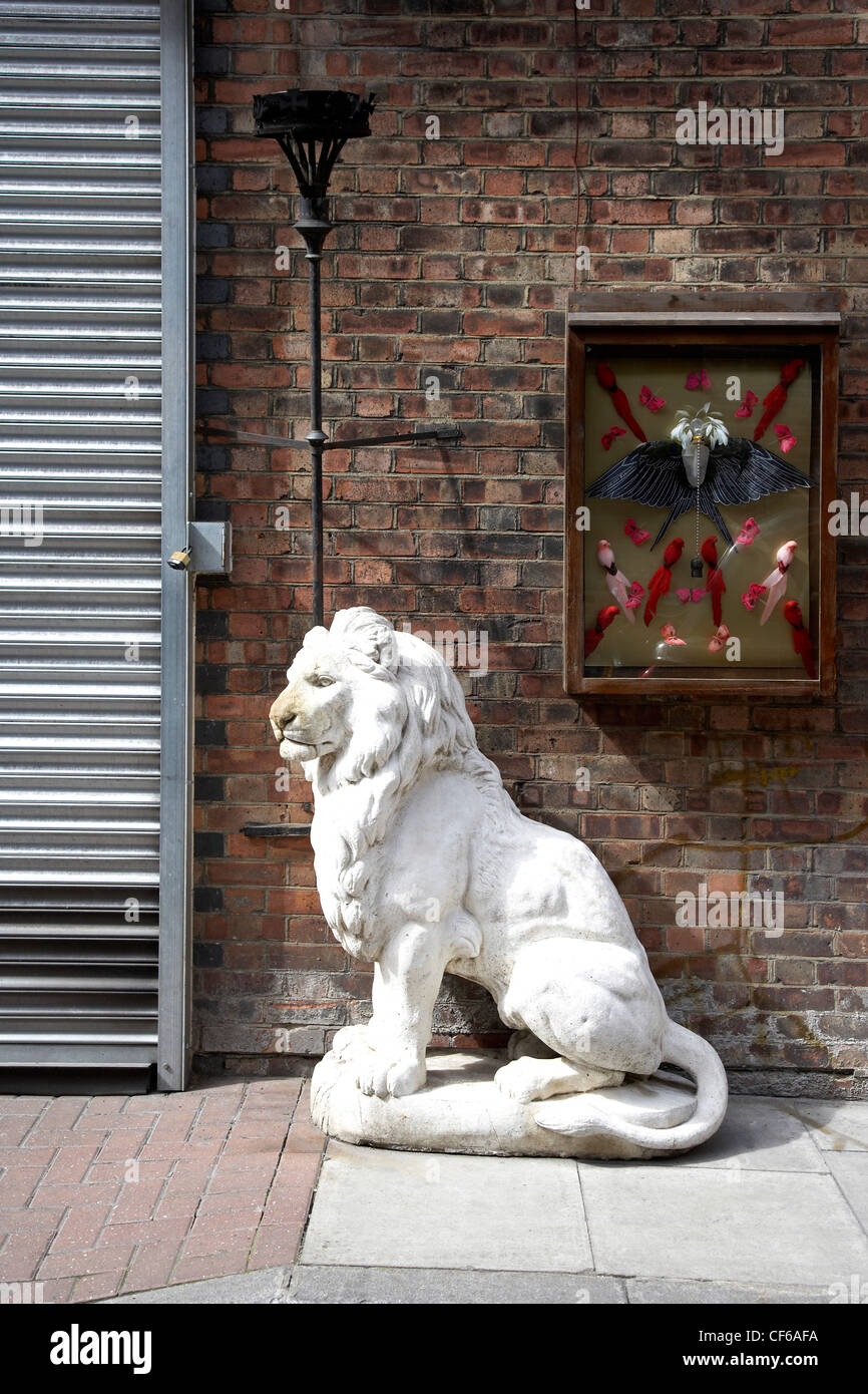 Un leone bianco scultura al di fuori di un negozio a Brick Lane. Foto Stock