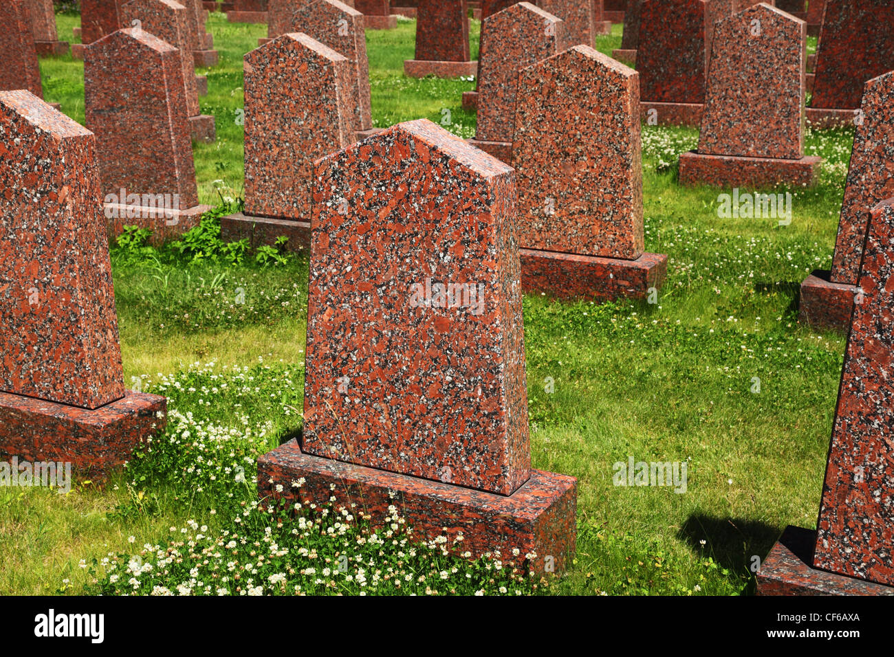 Gli obelischi di granito rosso in piedi in erba verde presso il sacrario militare Foto Stock
