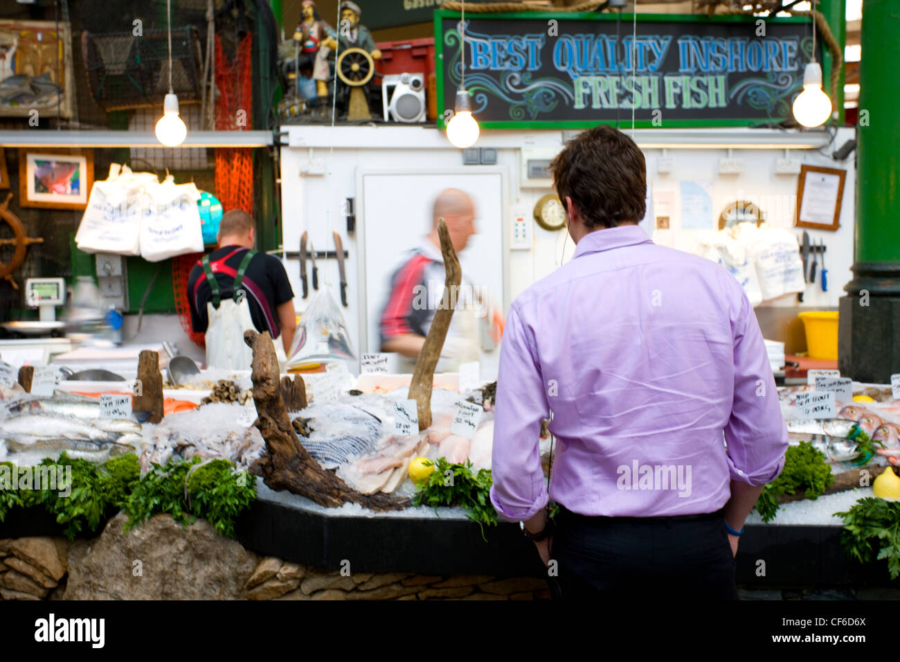 Un cliente di un pesce fresco in stallo Borough Market. Foto Stock