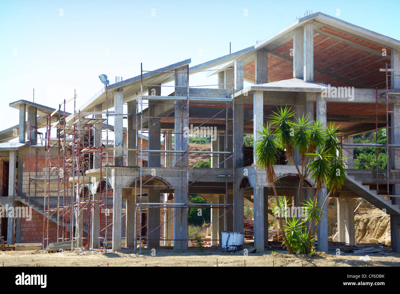 Sceleton di nuovo borgo casa cottage con scalinata frontale e palme sulla collina Foto Stock