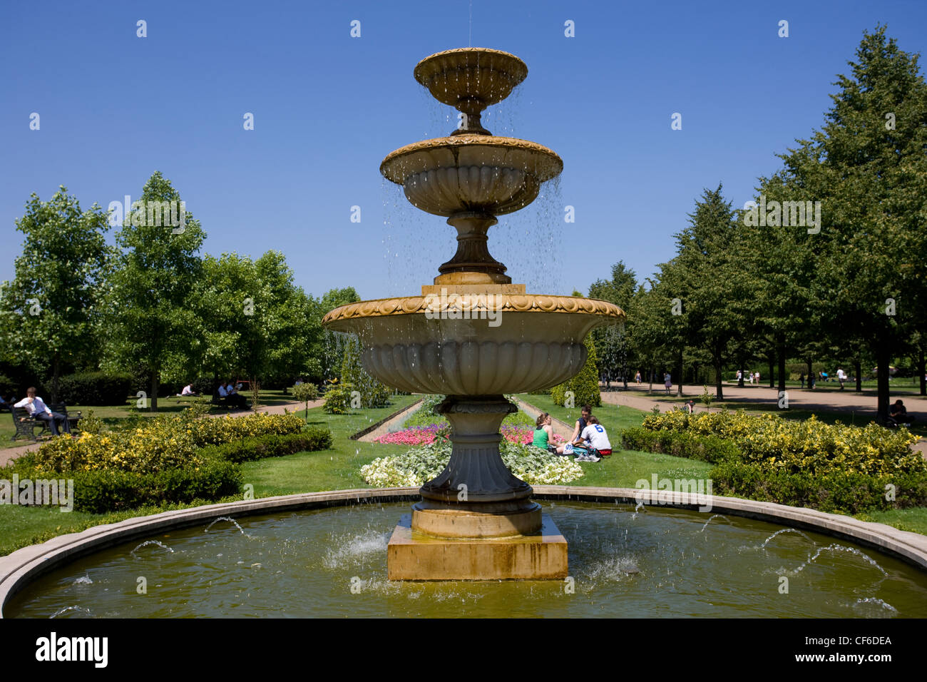 La gente seduta da una fontana in Regent's Park. Foto Stock