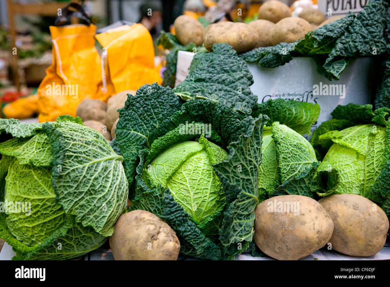 Patate e cavoli cappucci per la vendita su uno stallo nel mercato di Borough. Foto Stock