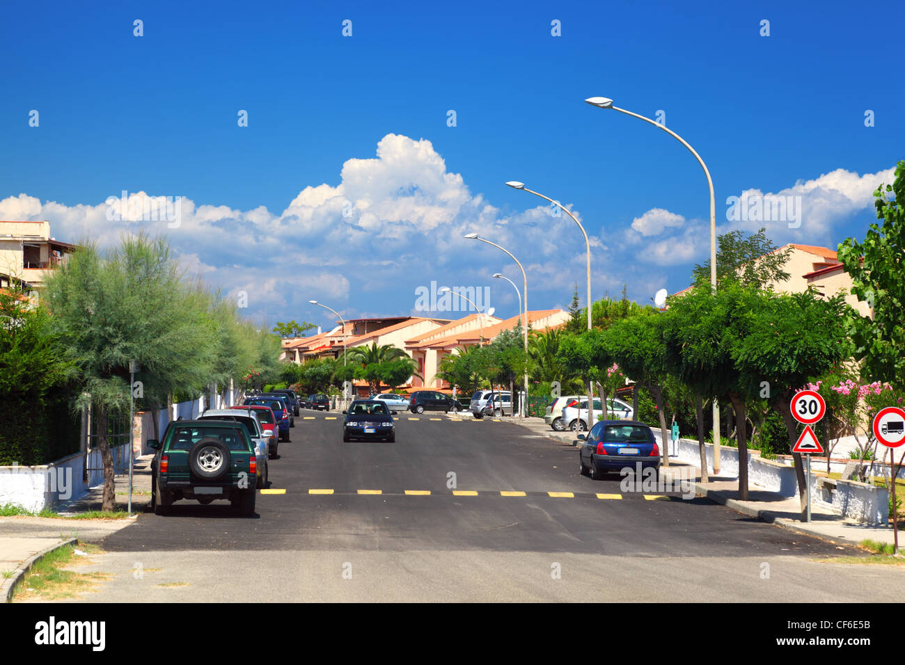 Di automobili che circolano su strada e sui marciapiedi sono le palme in zona residenziale. Foto Stock