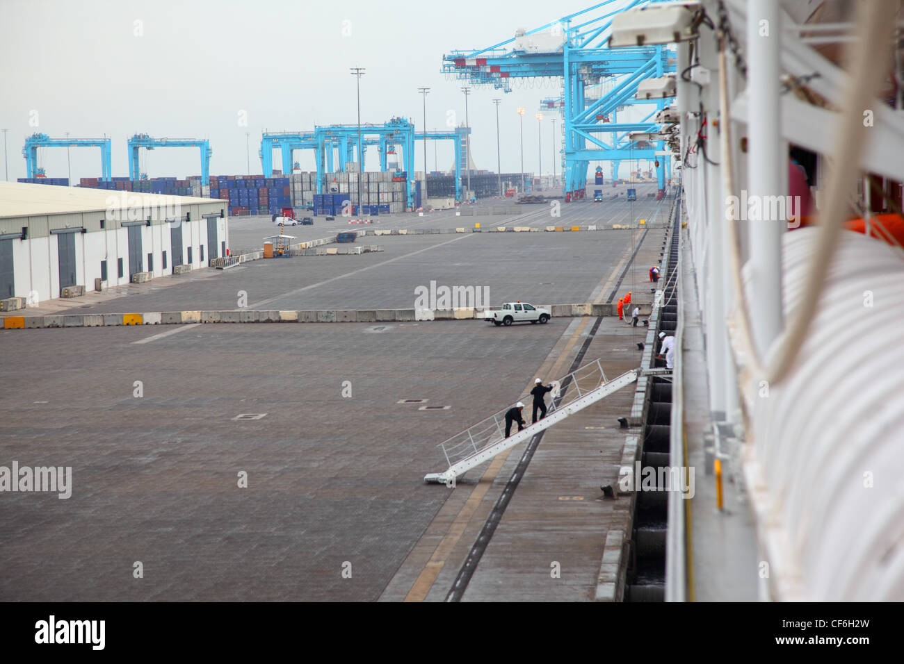 Gli uomini salire sulla nave ormeggiata al grande porto industriale alla giornata di nebbia Foto Stock