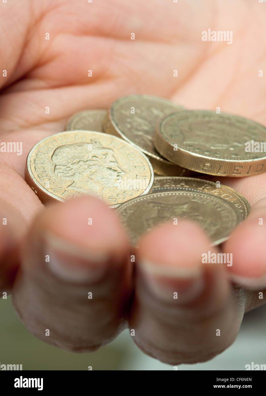 Contanti in mano. £ 1 monete. Regno Unito Foto Stock