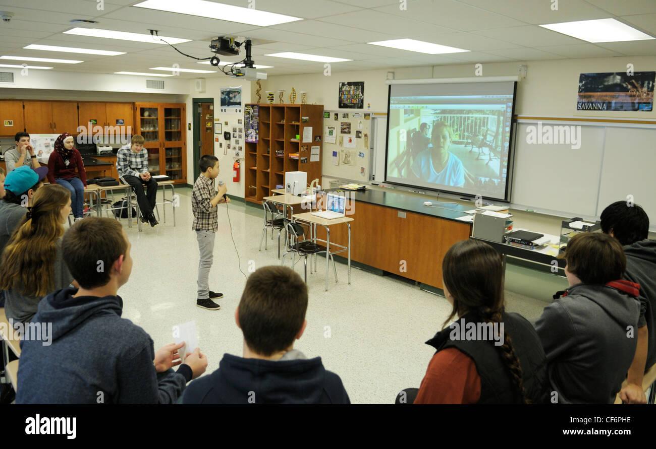 Classe di studenti americani in una videoconferenza con un ricercatore presso una stazione di campo in Panama- ragazzo con mic domande Foto Stock