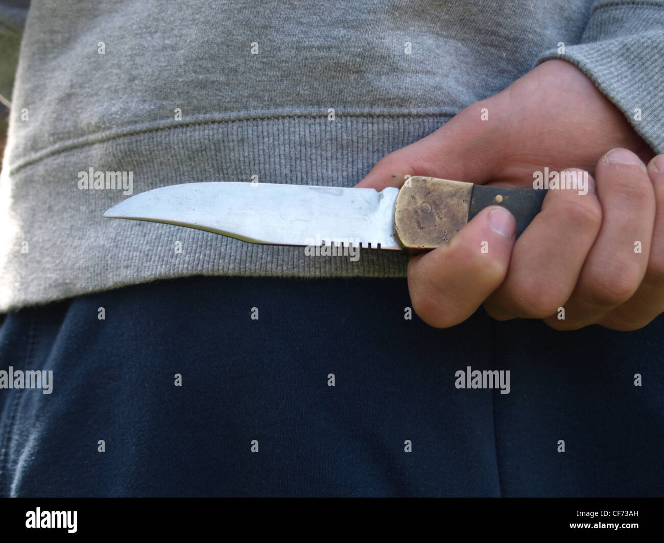 Voce maschile tenendo un coltello dietro la schiena Foto Stock