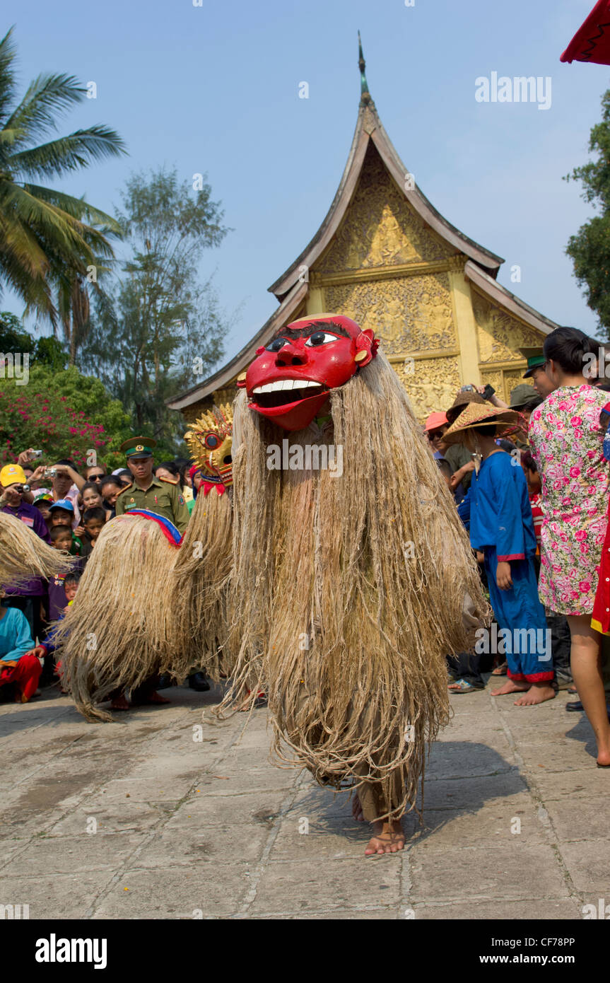 Masked Pou Nyer un leggendario antenato del popolo Lao dancing infront di golden Sim al Wat Xieng Thong sul Mue Nau, metà giornata di Lao Anno Nuovo (Pi Mai Lao), Luang Prabang, Laos Foto Stock