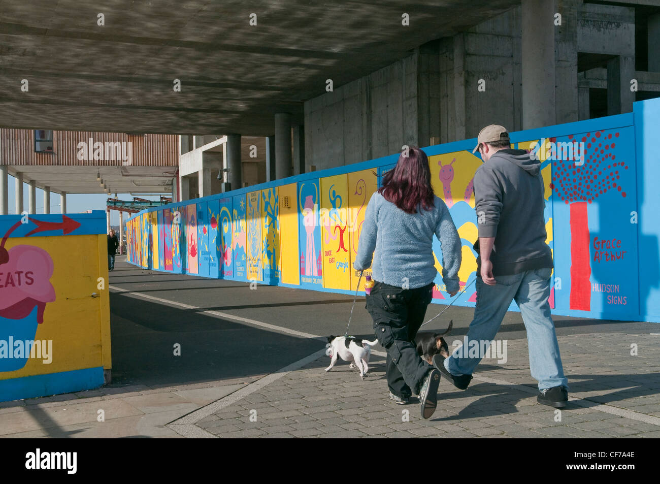 L uomo e la donna a piedi i cani. Lungomare di Ipswich, Suffolk, Regno Unito Foto Stock