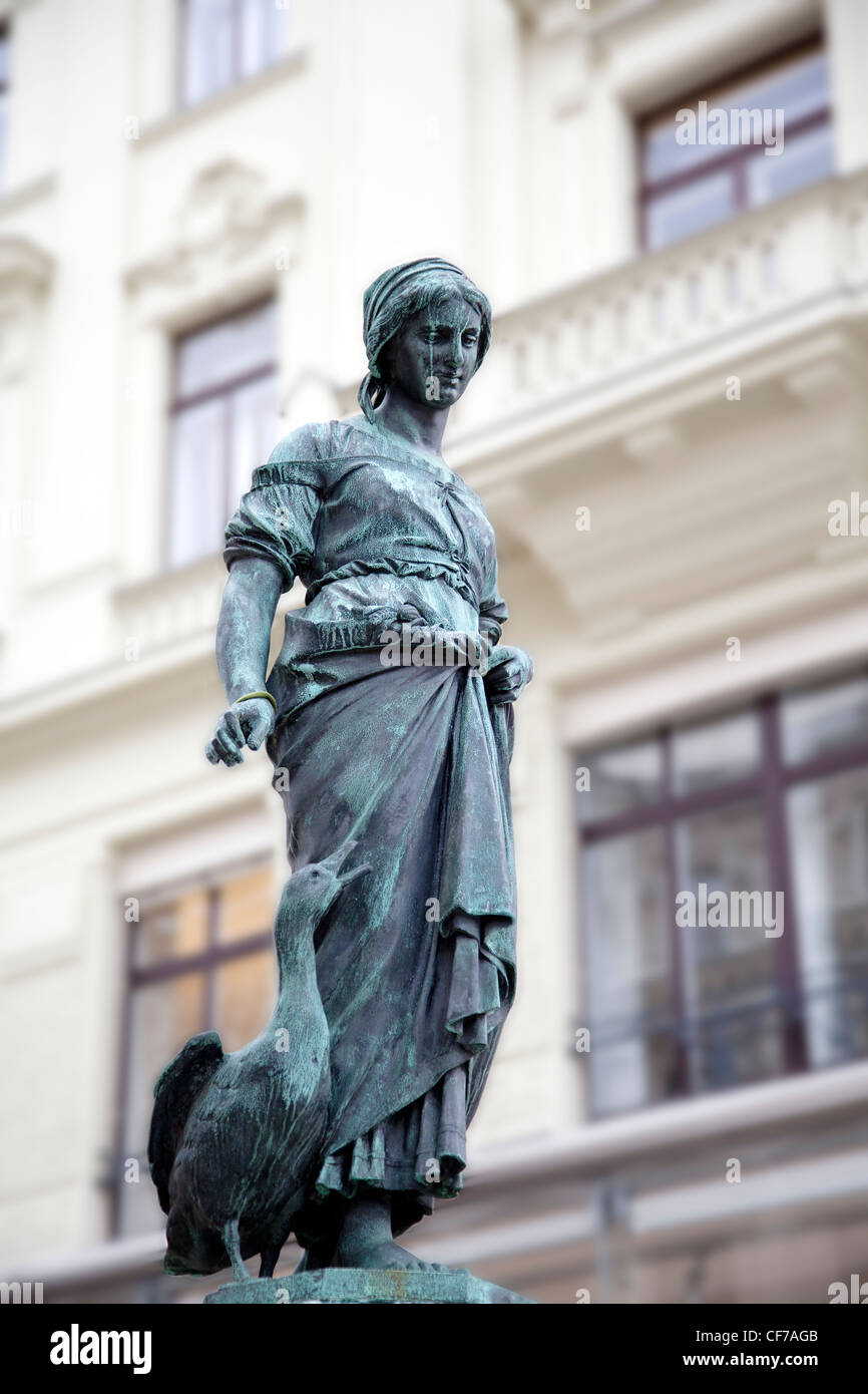 Statua di una ragazza con un oca nel quartiere Neubau di Vienna Austria. Questa statua si trova sulla parte superiore della fontana con cigni. Foto Stock