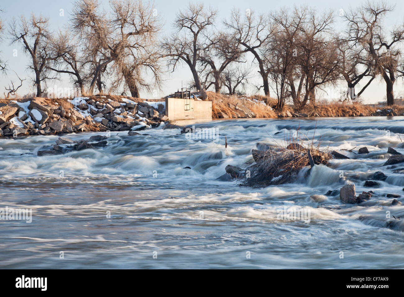 Una diga piccola deviazione di acqua per irrigazione di terreni agricoli, South Platte nel fiume Colorado orientale vicino Greeley, paesaggio invernale Foto Stock