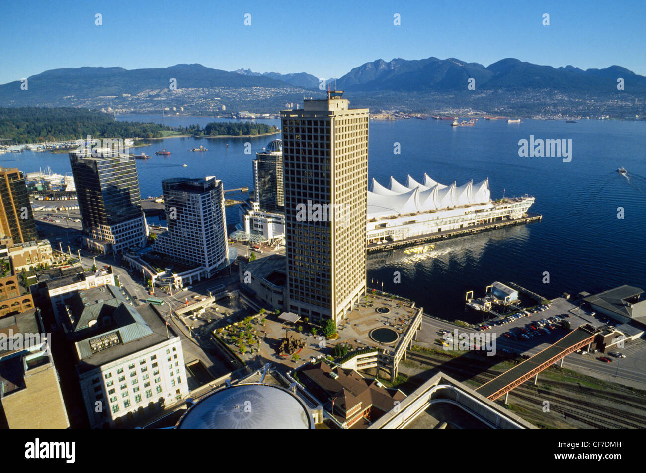 Una veduta aerea del centro cittadino di Vancouver waterfront in British Columbia, Canada, sembra passato edifici alti e barca ormeggiata al North Shore Mountains. Foto Stock