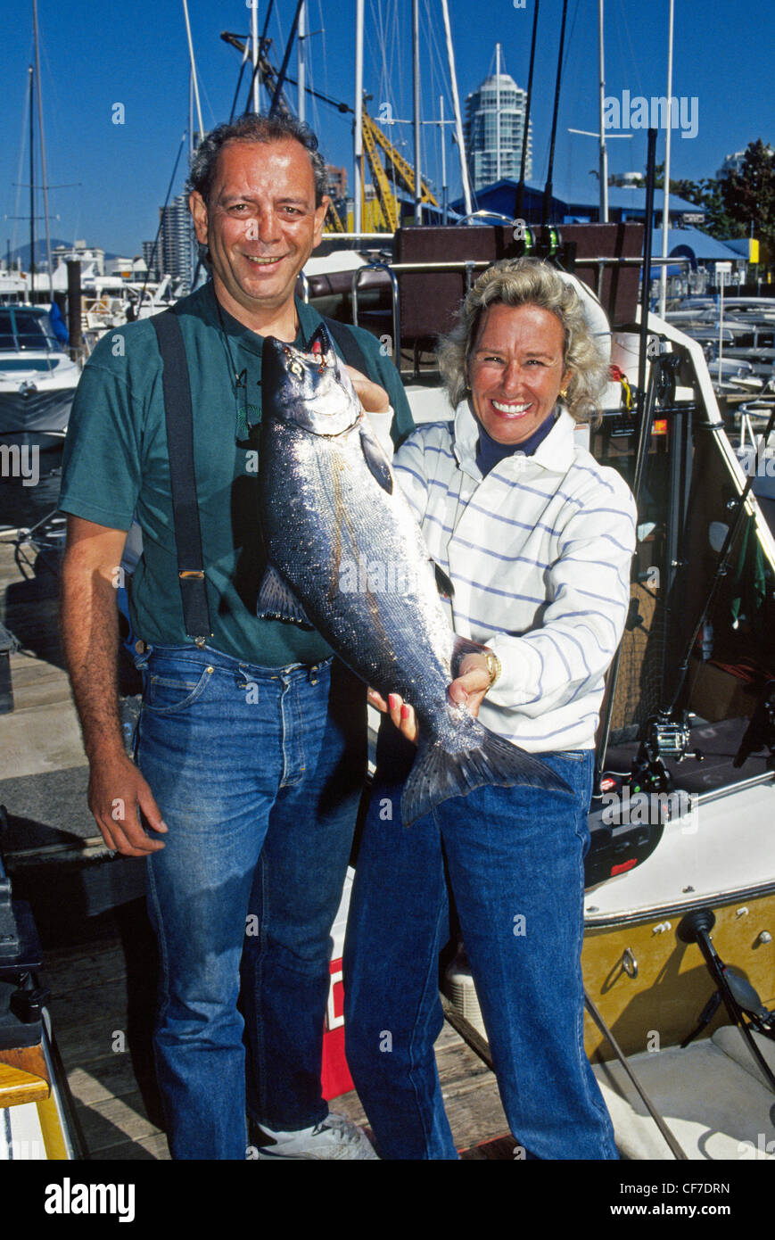 Un fisherwoman mostra con orgoglio un salmone chinook ha catturato su una carta sportfishing barca che funziona da Vancouver, British Columbia, Canada. Foto Stock