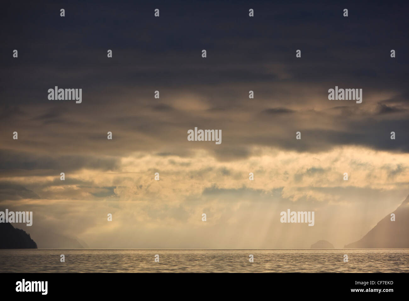 Sunrise con drammatica delle nuvole in una giornata di pioggia in ingresso del cavaliere, British Columbia, Canada. Foto Stock