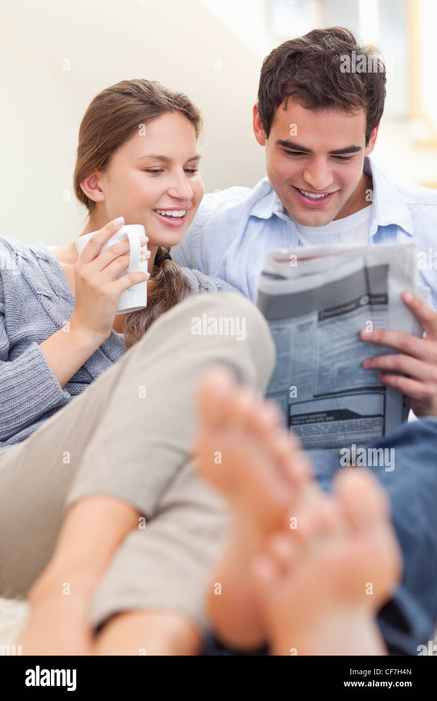 Ritratto di una coppia felice la lettura di un quotidiano al mattino Foto Stock