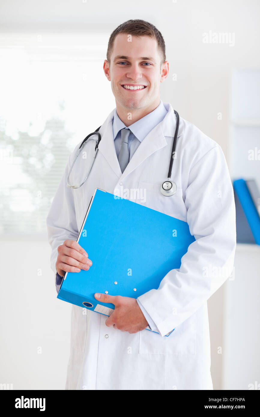 Medico sorridente con cartella Foto Stock