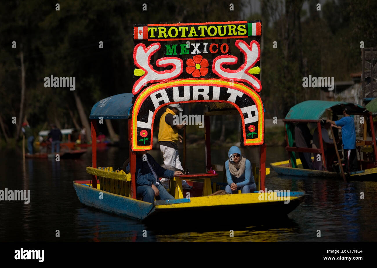 I turisti trevel in barca attraverso i canali di acqua di Xochimilco sul lato sud di Città del Messico Foto Stock