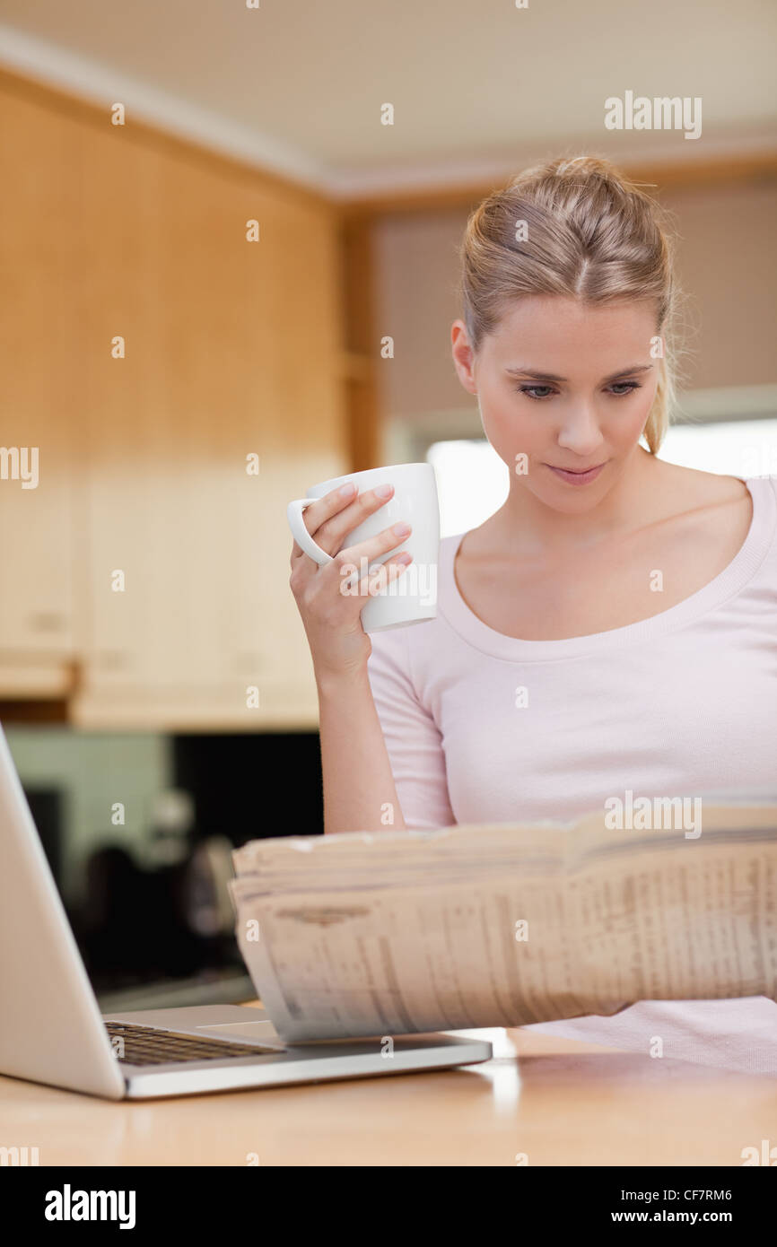 Ritratto di una donna che legge le notizie mentre un caffè Foto Stock