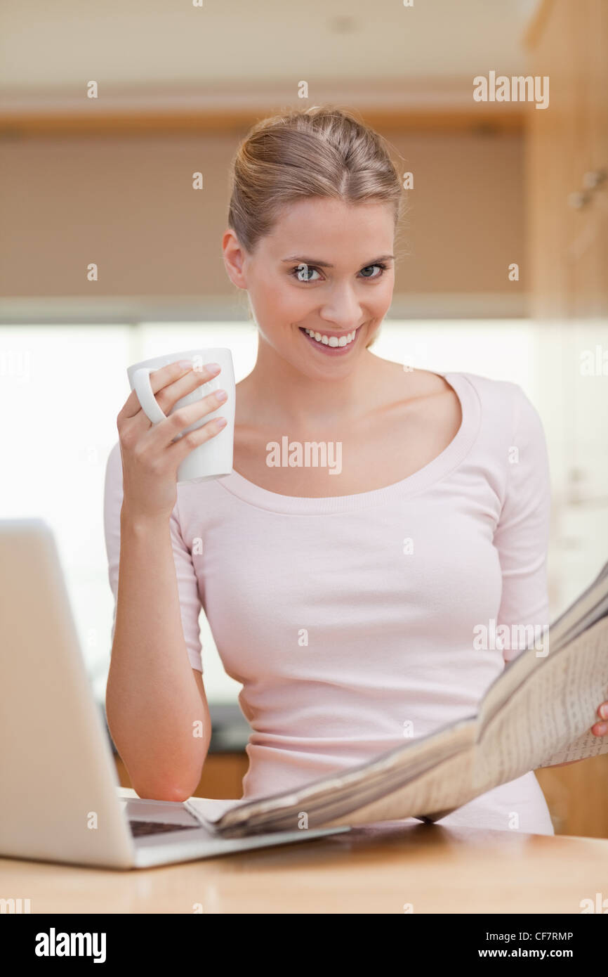 Ritratto di una donna che legge il giornale mentre un caffè Foto Stock