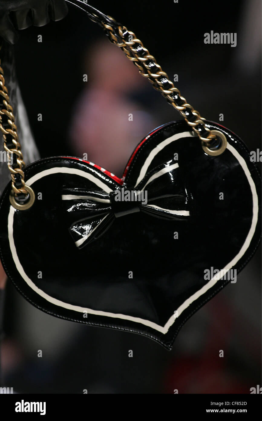 Moschino Cheap & Chic pronto a indossare a Milano un W ravvicinata di un brevetto nero in pelle a forma di cuore borsetta di colore rosso e bianco macchiato Foto Stock