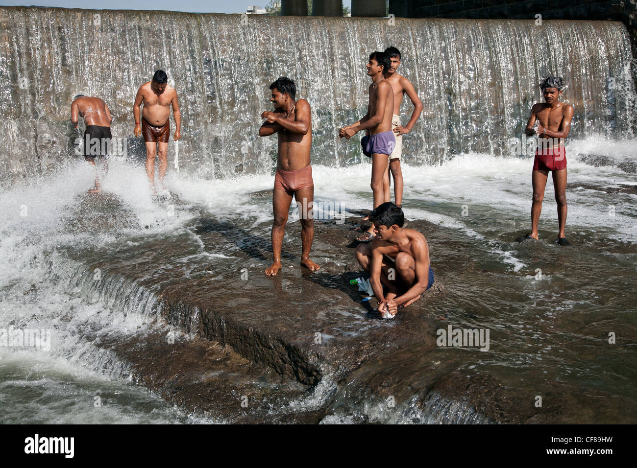 Indian uomini rendendo le abluzioni rituali nelle sacre acque del fiume Godavari. Ram Kund. Nasik. India Foto Stock