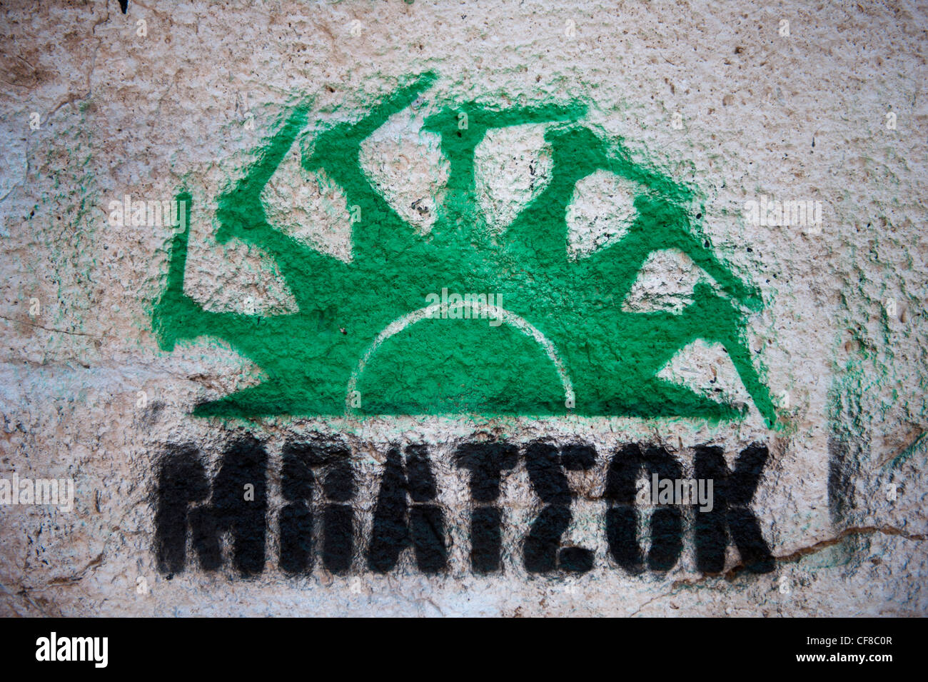 Anti PASOK Graffiti in Atene in Grecia. Il simbolo del partito socialista - un sole verde - sostituita dalla polizia manganelli Foto Stock