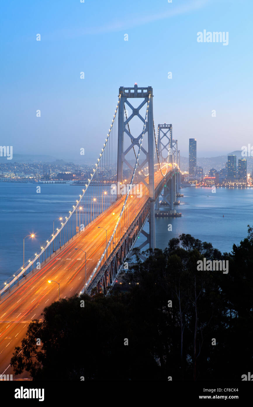 Stati Uniti, California, San Francisco, Oakland Bay Bridge al tramonto e dello skyline della città Foto Stock