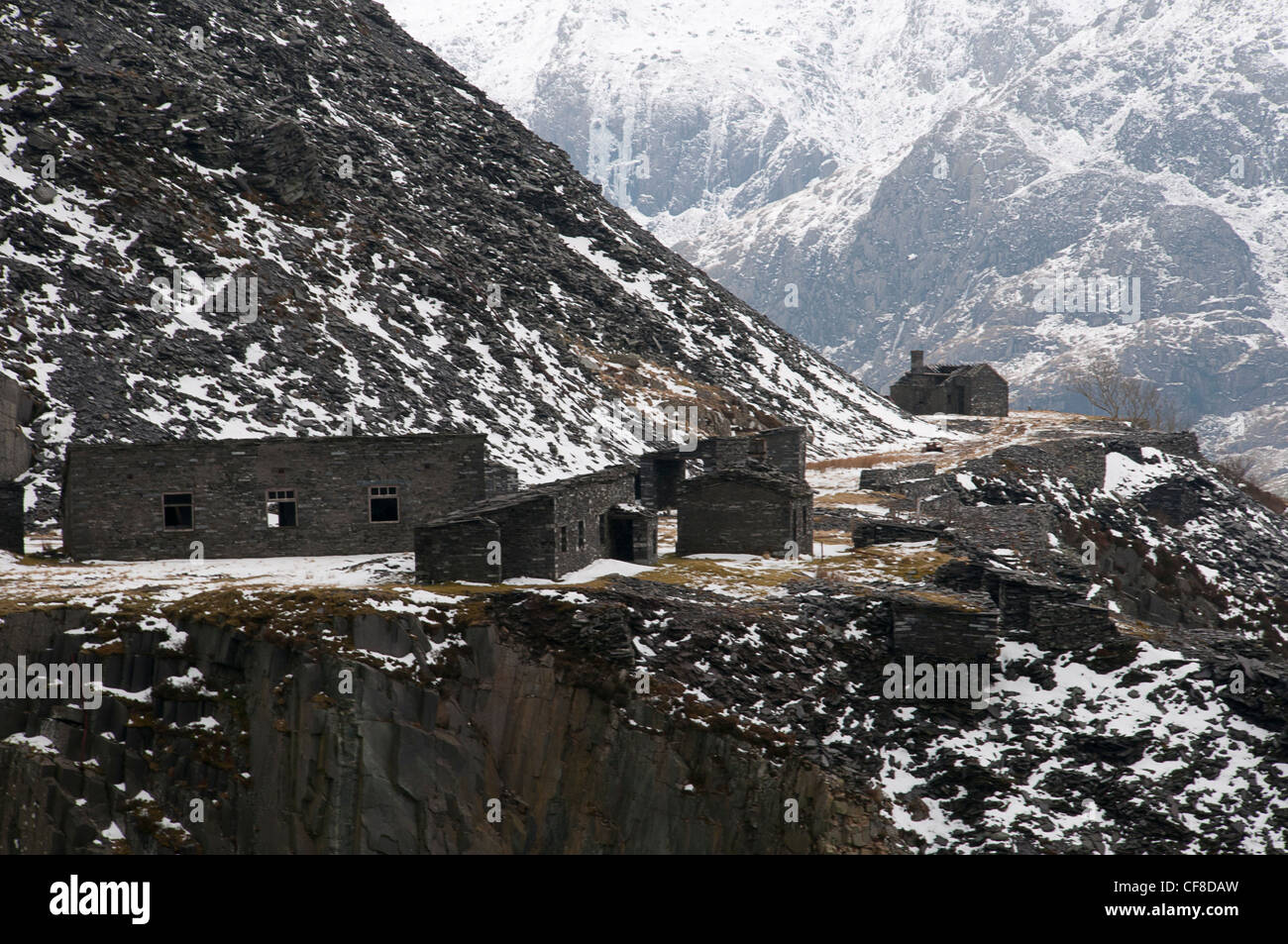 Edifici in disuso e rifiuti di ardesia guardando oltre Llyn Peris in cava di Dinorwig a Llanberis Galles del Nord Foto Stock