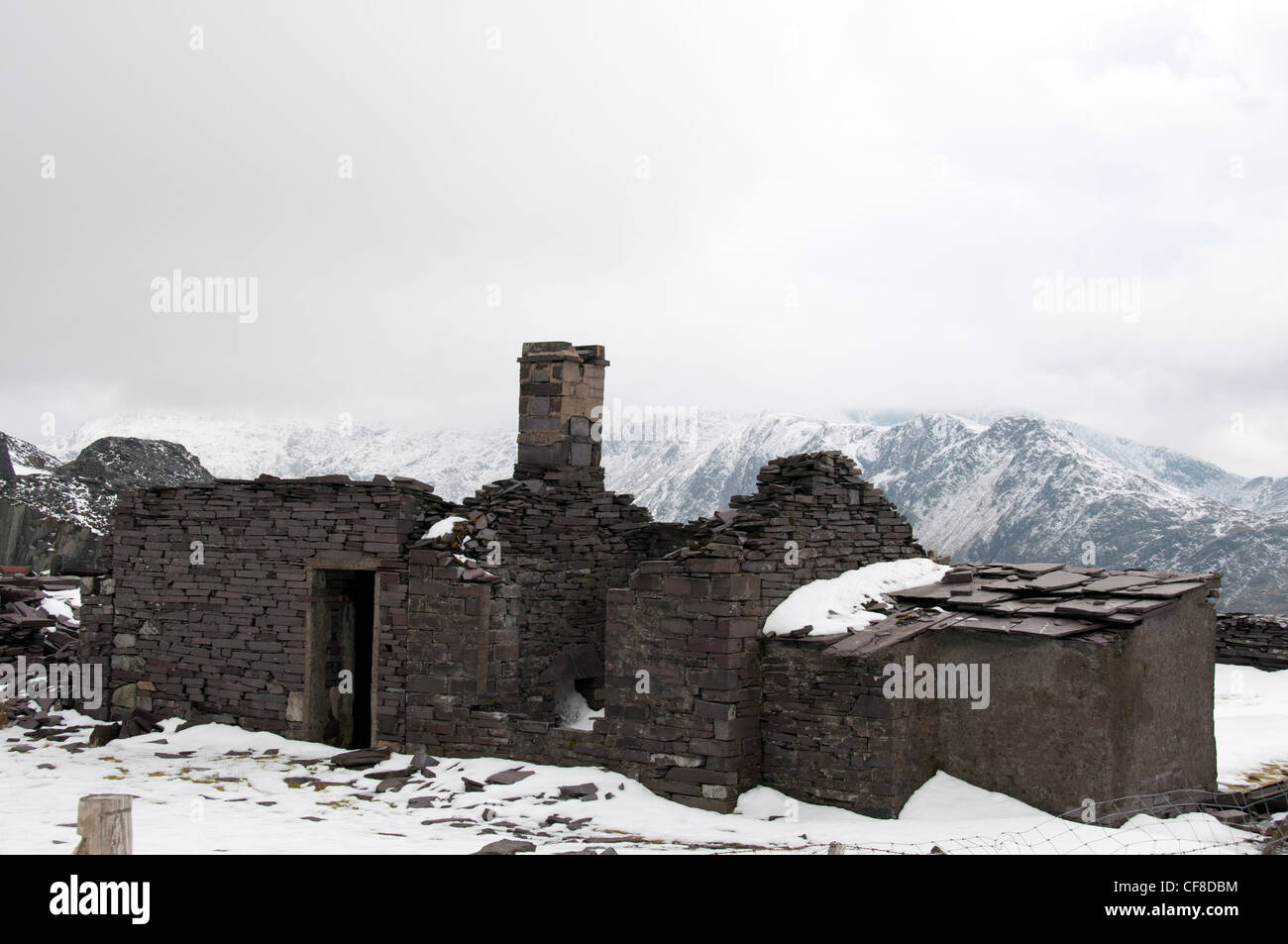Costruzioni abbandonate e rifiuti di ardesia nella cava in disuso a Dinorwig affacciato Llyn Peris. Foto Stock
