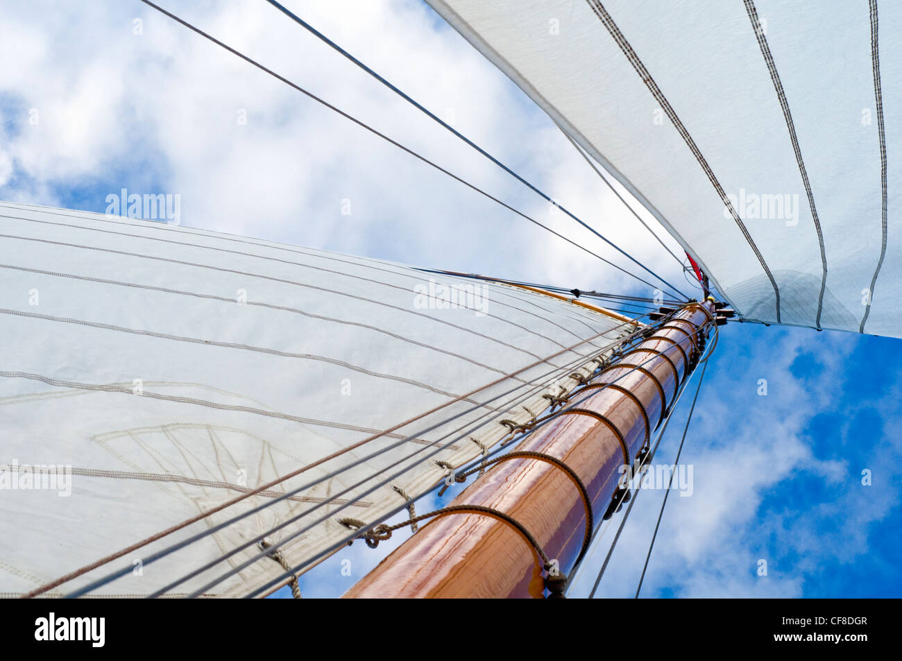 Il montante e le vele di un grande yacht contro un cielo blu Foto Stock