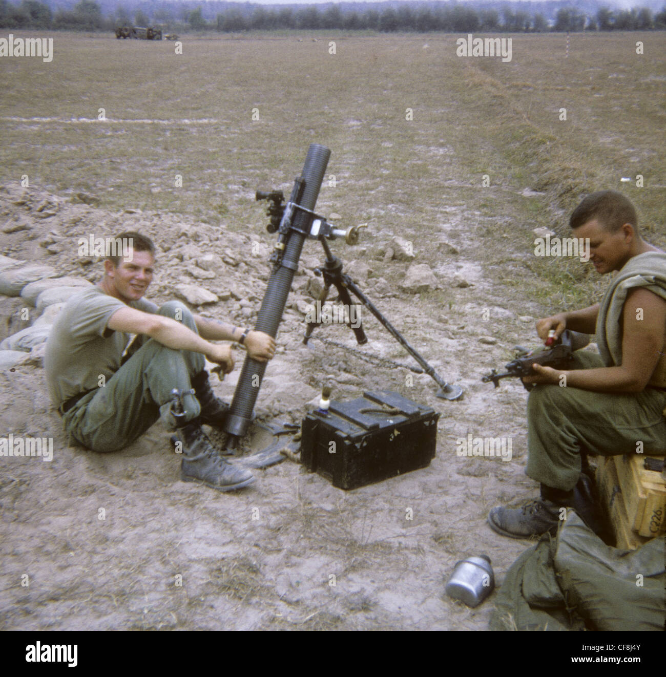 Pulizia soldato m-14 soldati di fucile seduto accanto al tubo di mortaio 1/5 (Mechanized) Fanteria CU CHI Guerra del Vietnam 1966 M113 armore Foto Stock