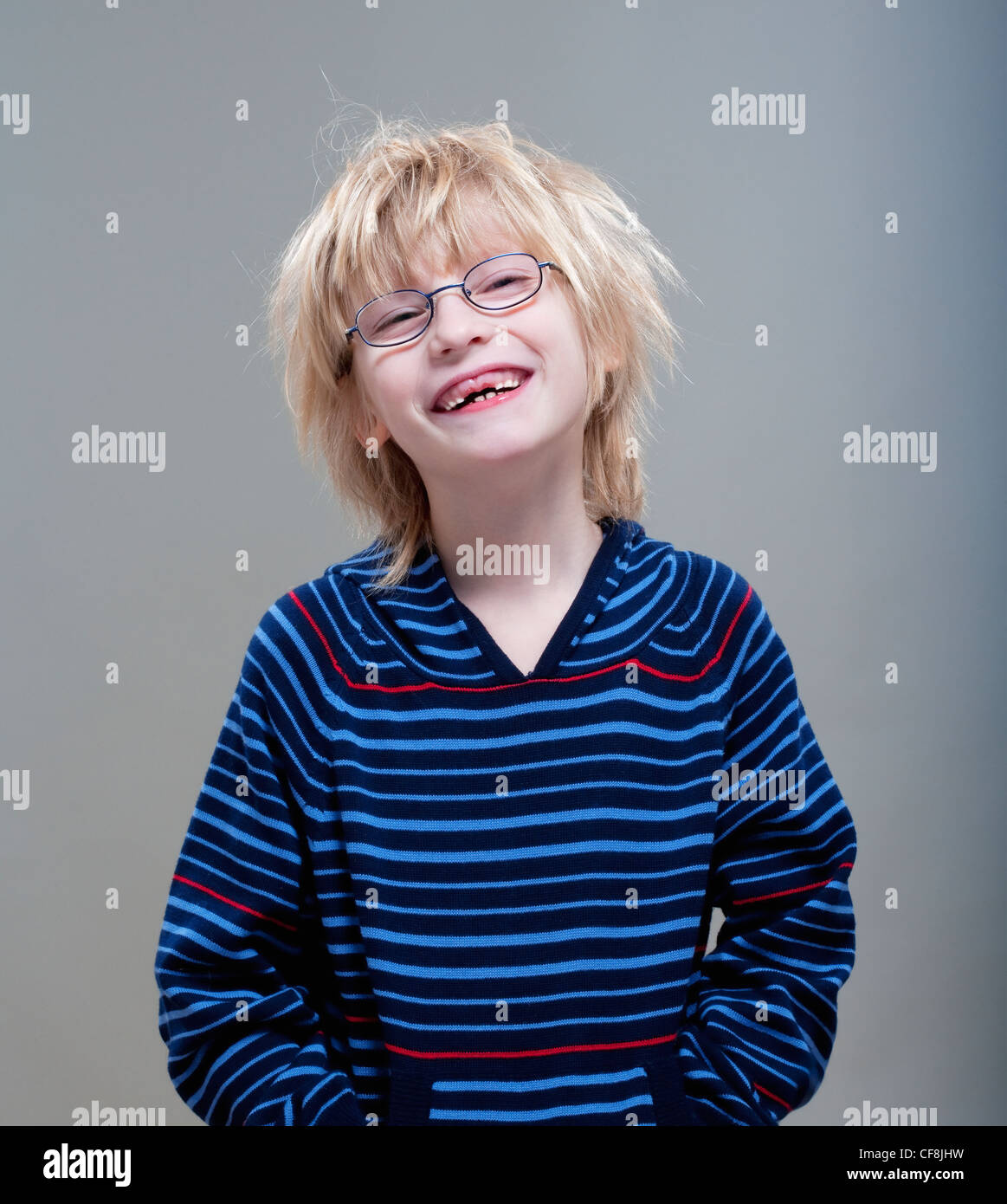 Ritratto di un ragazzo con gli occhiali che mostra il suo primo mancano i denti di latte Foto Stock
