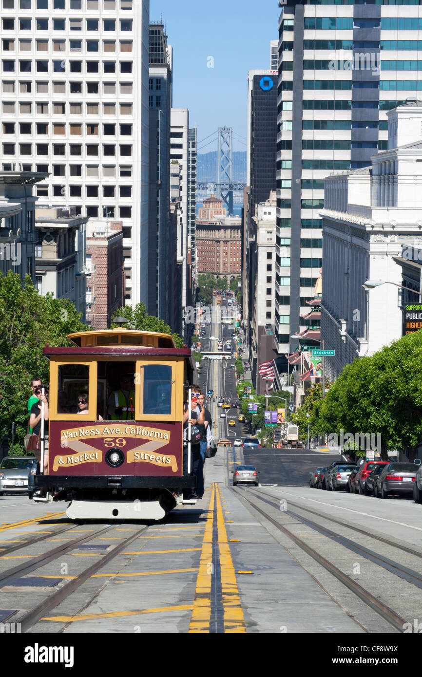 Funivia attraversando California Street con il Bay Bridge sfondo in San Francisco, California, Stati Uniti d'America Foto Stock