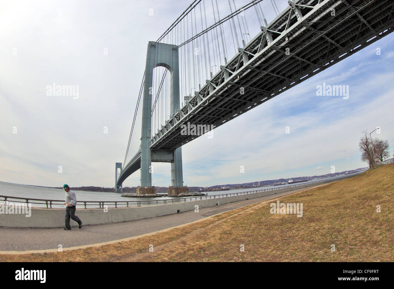 Un uomo jogging sotto il Verrazano Narrows Bridge Brooklyn New York City Foto Stock