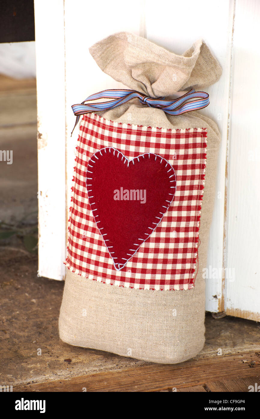 Per fare un piccolo pezzo di tessuto di lino viene tagliata e un cuore è cucita sul feltro in una coperta stitch cucire insieme i lati e quindi riempire Foto Stock