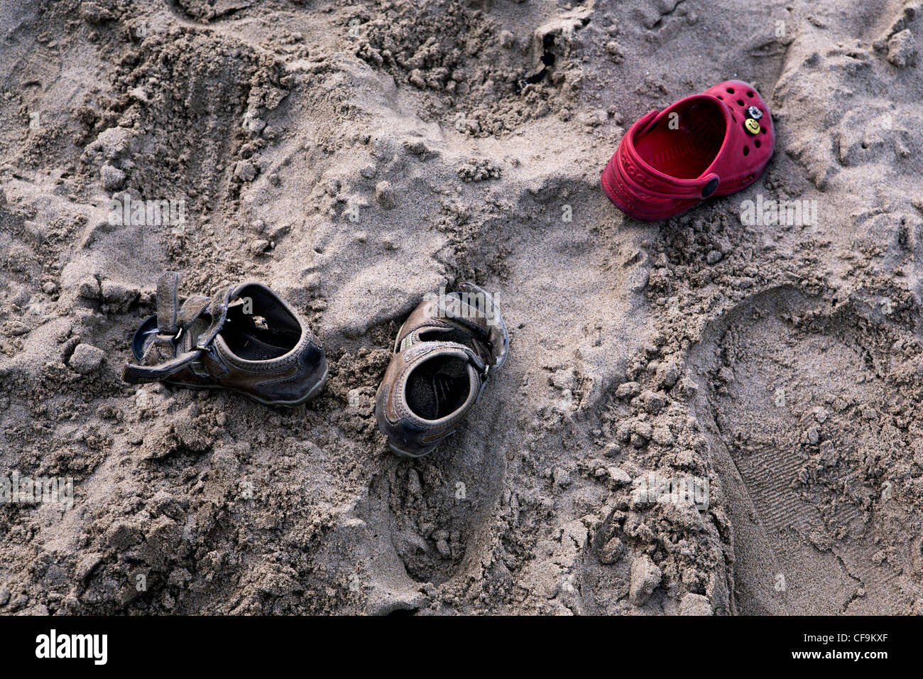 Le calzature per bambini a sinistra sulla spiaggia sabbiosa Foto Stock