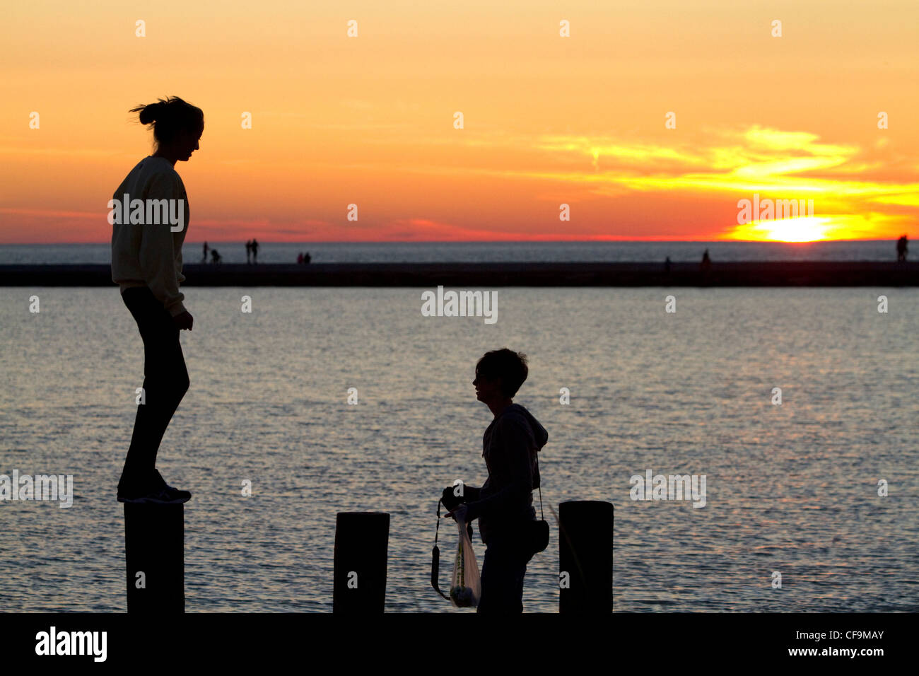 La gente guarda il tramonto sul Lago Michigan presso Pere Marquette porto situato in Ludington, Michigan, Stati Uniti d'America. Foto Stock