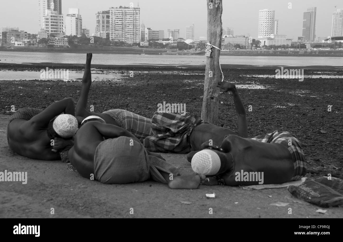 Gruppo di mendicanti con la lebbra chant a Haji Ali moschea, Mumbai India Foto Stock