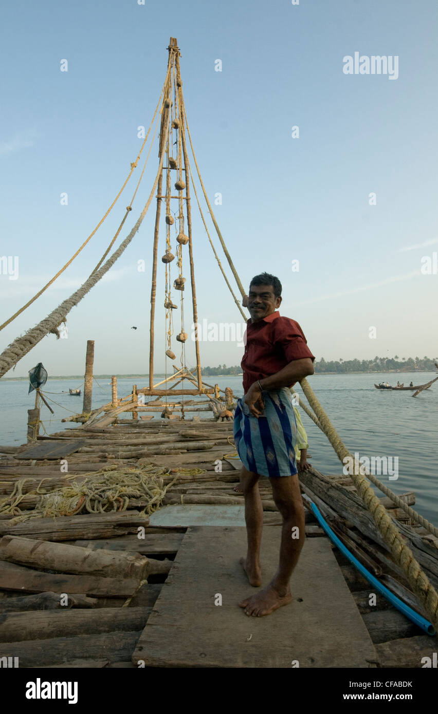 Pescatore indiano Babu su cinese la sua rete da pesca Foto Stock