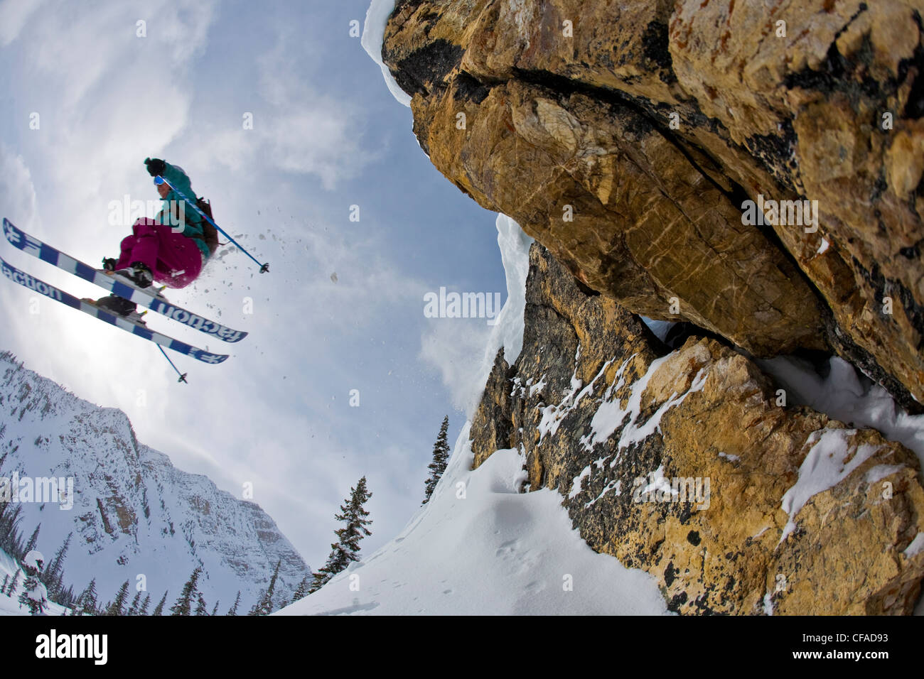 Una femmina di sciatore vola fuori da una scogliera di Kicking Horse Resort, Golden, BC Foto Stock