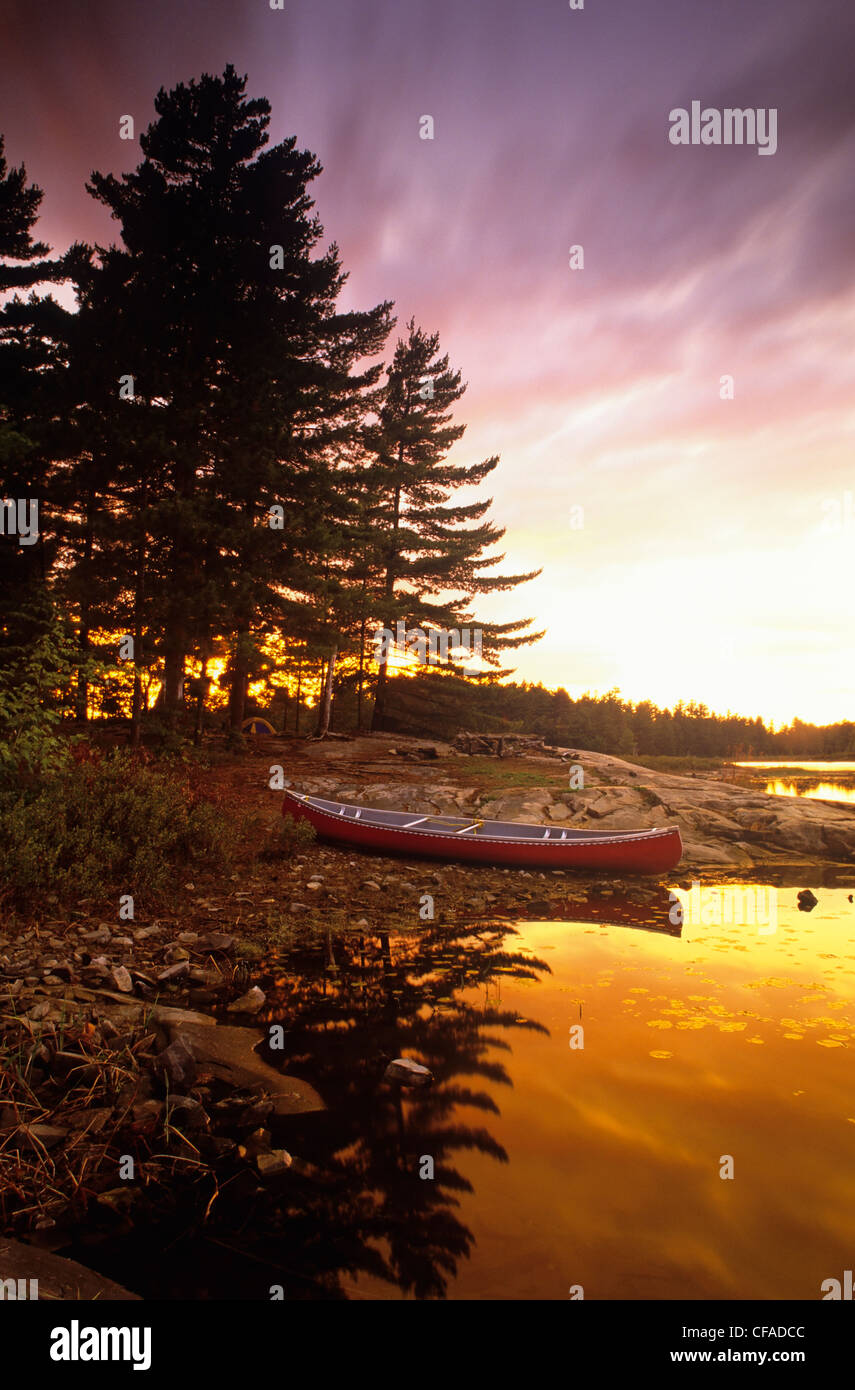 Una canoa seduta onshore in un campeggio, al tramonto, Killarney Provincial Park, Ontario, Canada. Foto Stock