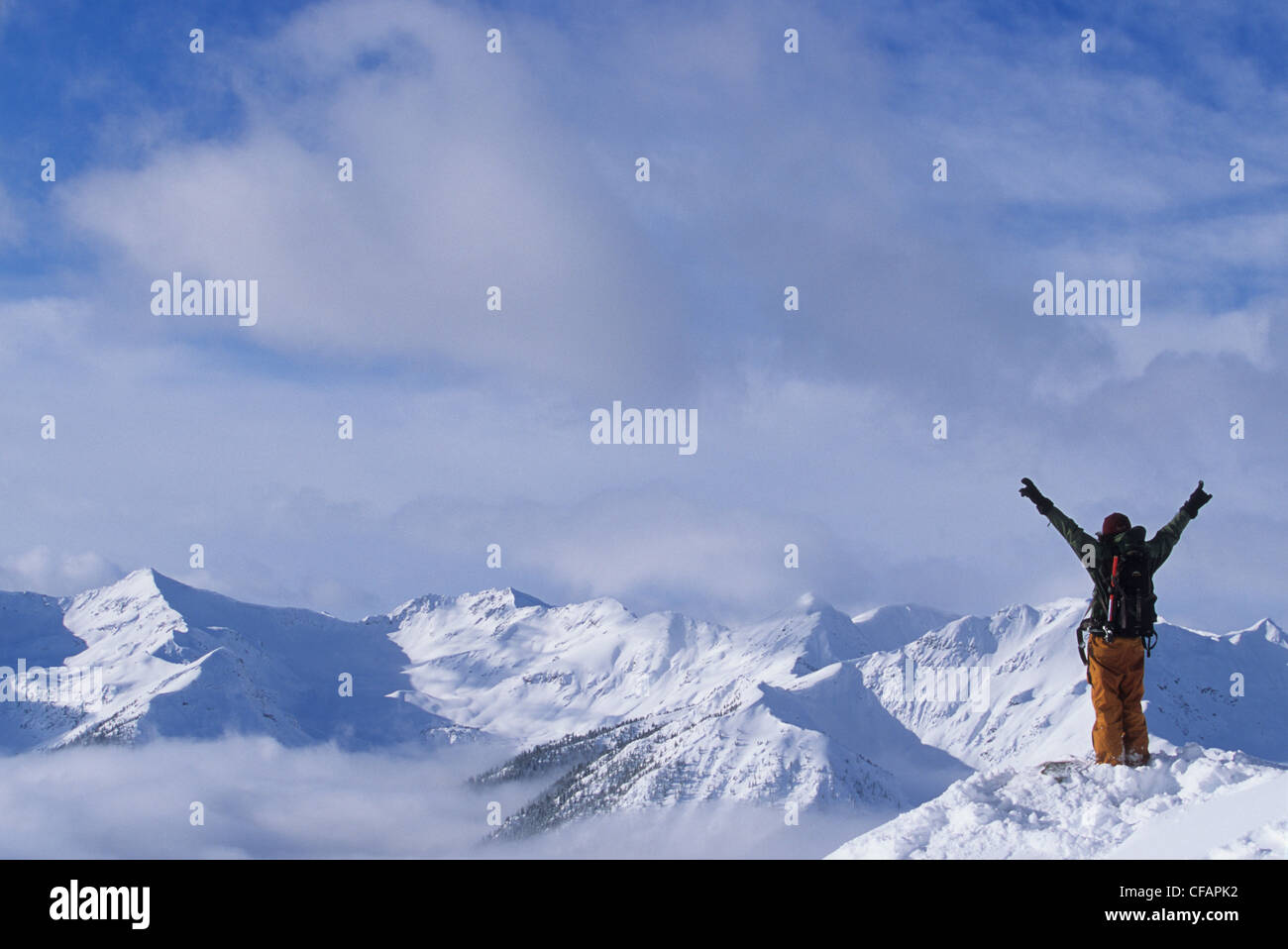 Uno sciatore godendo della vista delle cime innevate nel backcountry, Purcell gamma, Golden, British Columbia, Canada Foto Stock