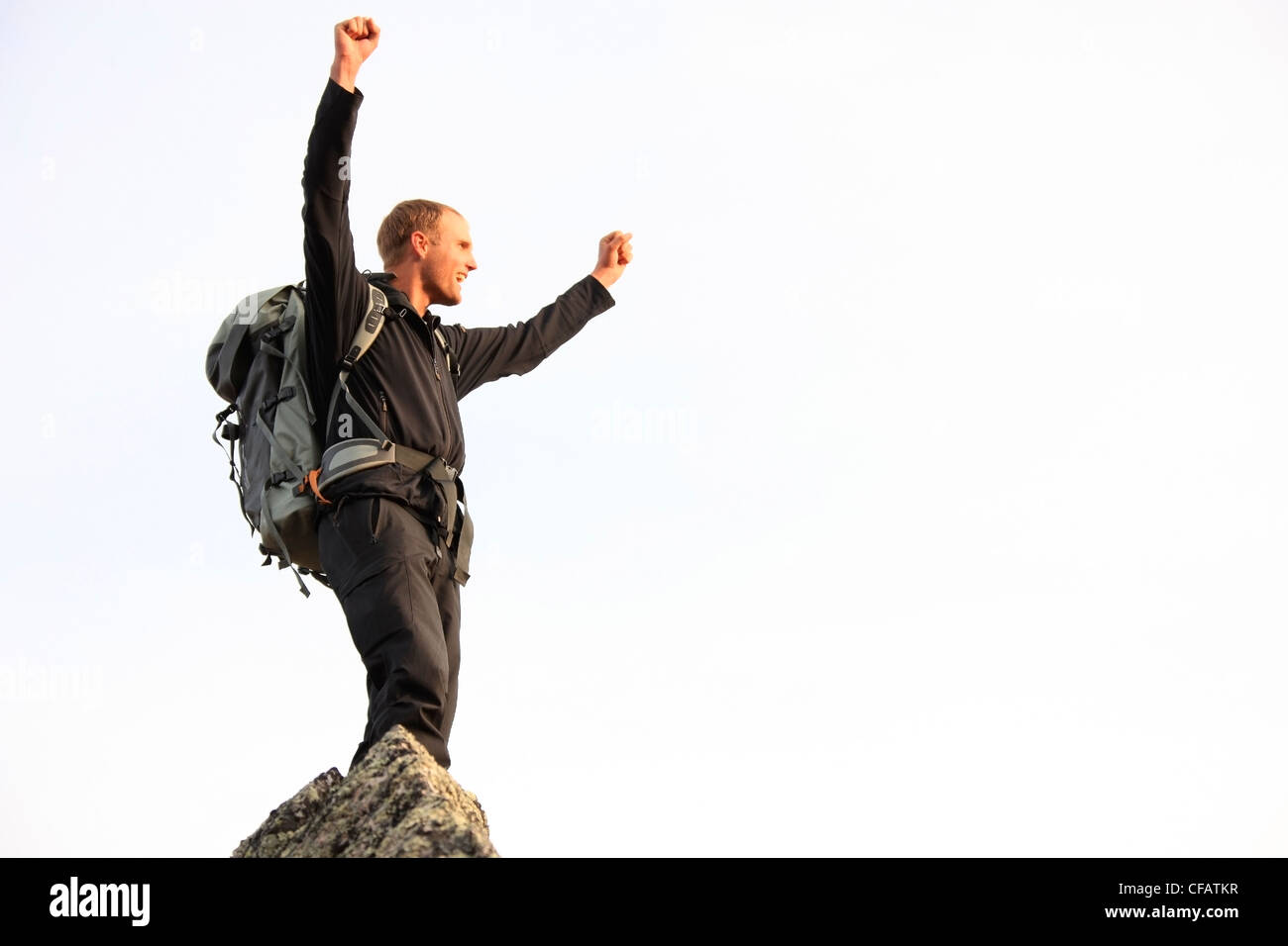 Giovane uomo alza il pugno in trionfo dopo aver scalato una montagna, Yukon, Canada Foto Stock