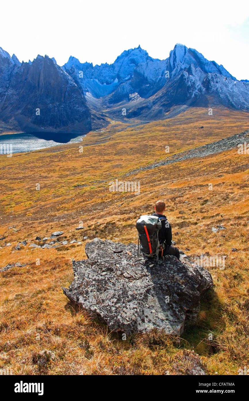 Escursionista prendendo una pausa e guardando il Monte monolito e dividere il lago in oggetto contrassegnato per la rimozione definitiva parco territoriale, Yukon, Canada Foto Stock