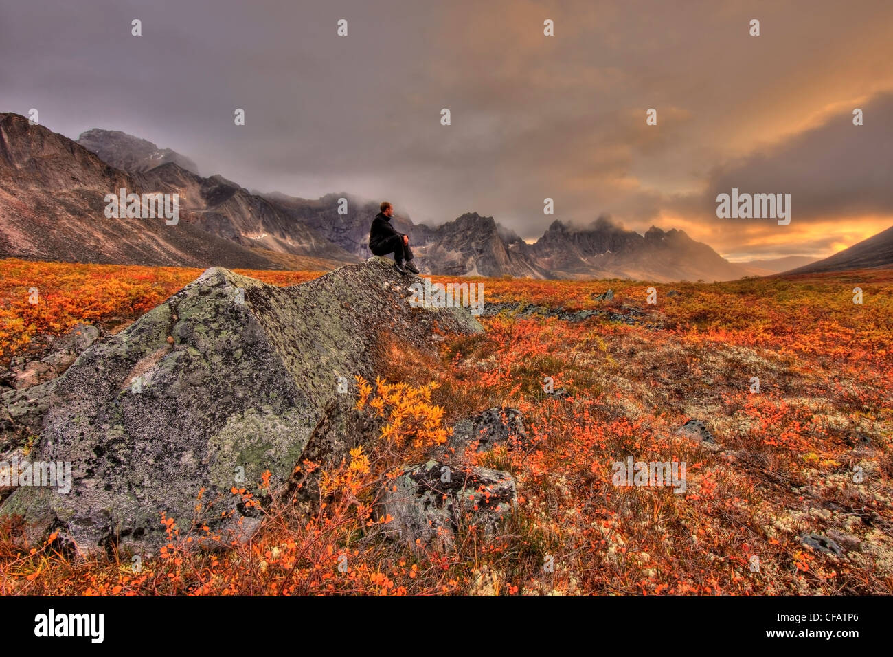 Escursionista prendendo una pausa per guardare il tramonto in pietra tombale parco territoriale, Yukon, Canada Foto Stock