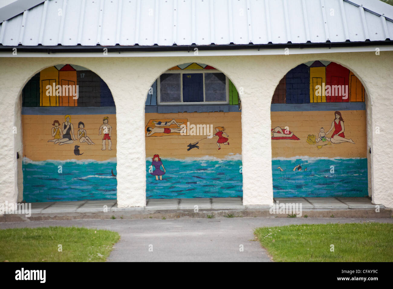 Guardando attraverso gli archi sulla scena della spiaggia dipinta sull'edificio di Hamworthy Park, Poole, Dorset UK a giugno Foto Stock